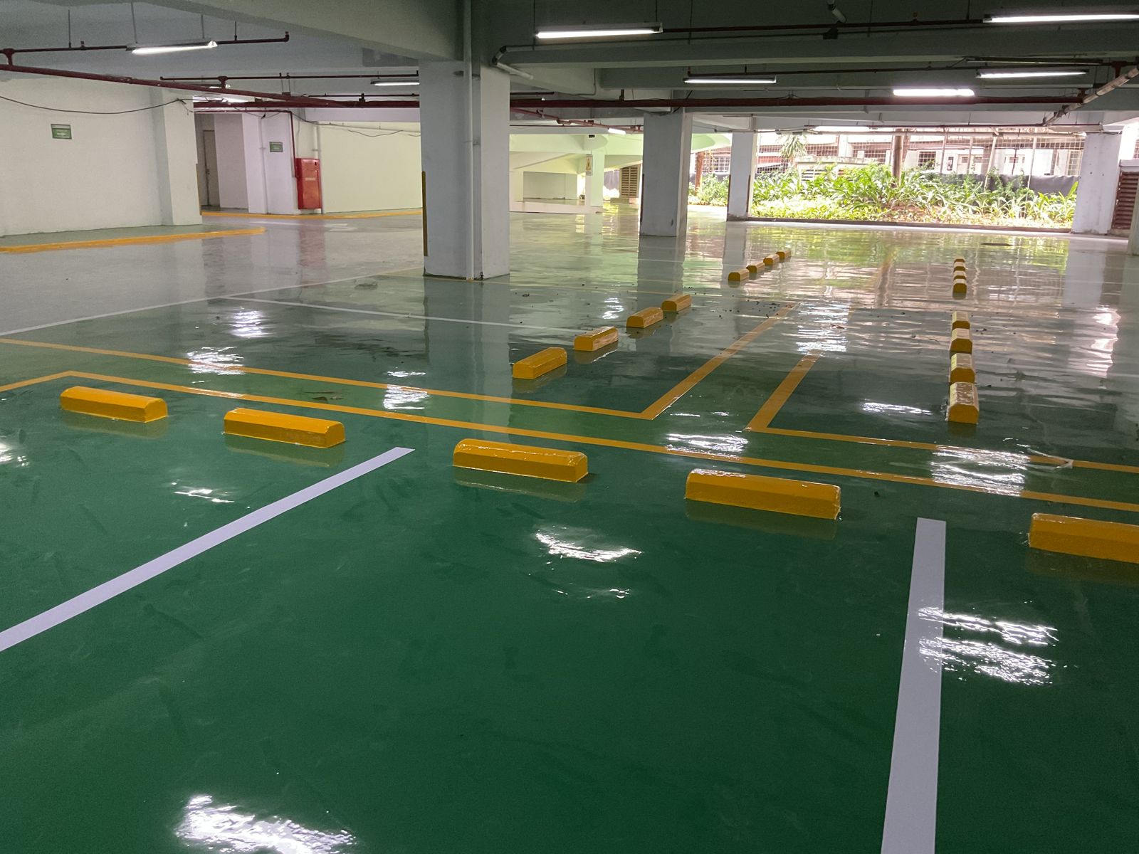Basement parkir Springhill Royale Suites dengan lantai epoxy hijau dan marka jalur putih (10/14)