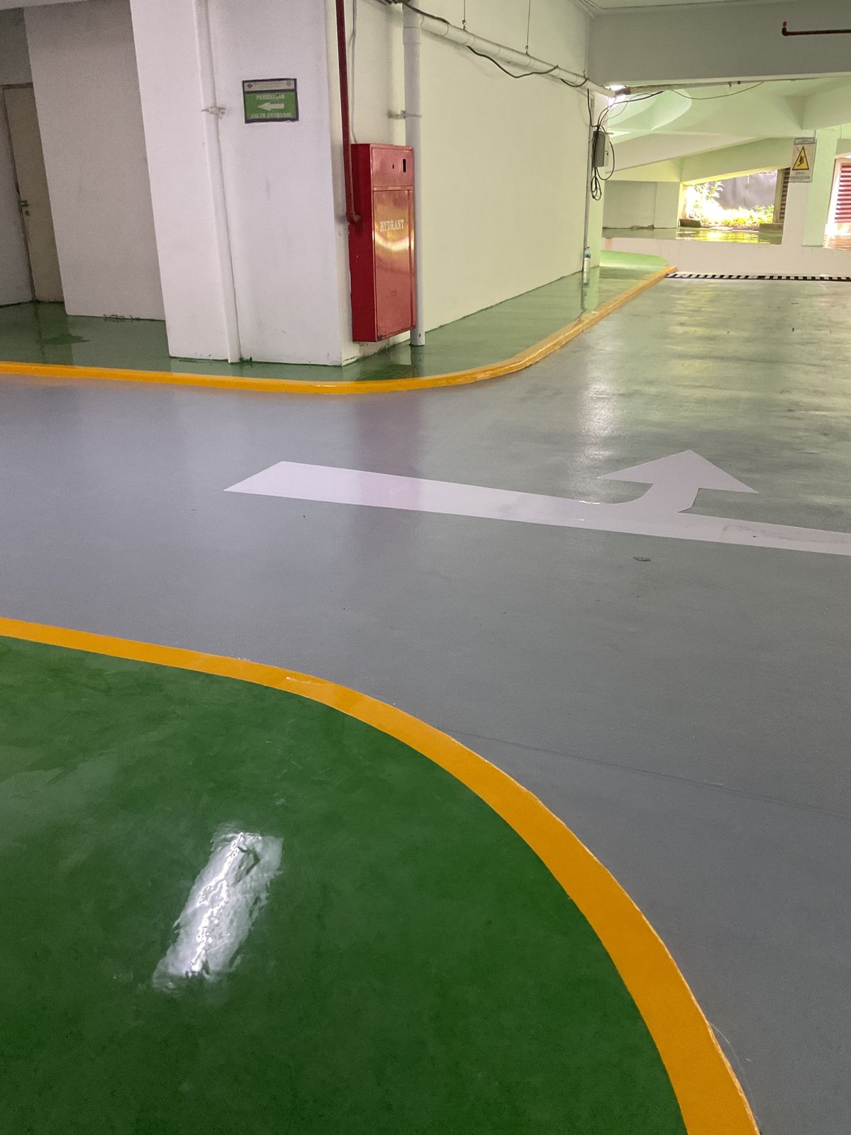 Basement parkir Springhill Royale Suites dengan lantai epoxy hijau dan marka jalur putih (11/14)