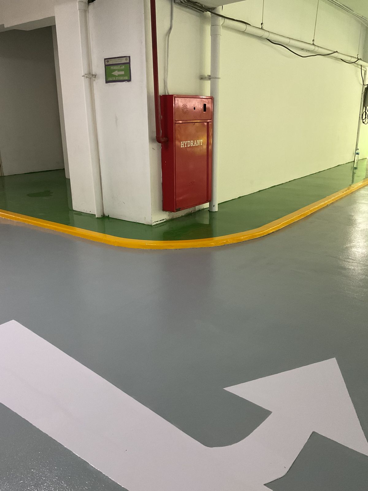 Basement parkir Springhill Royale Suites dengan lantai epoxy hijau dan marka jalur putih (12/14)