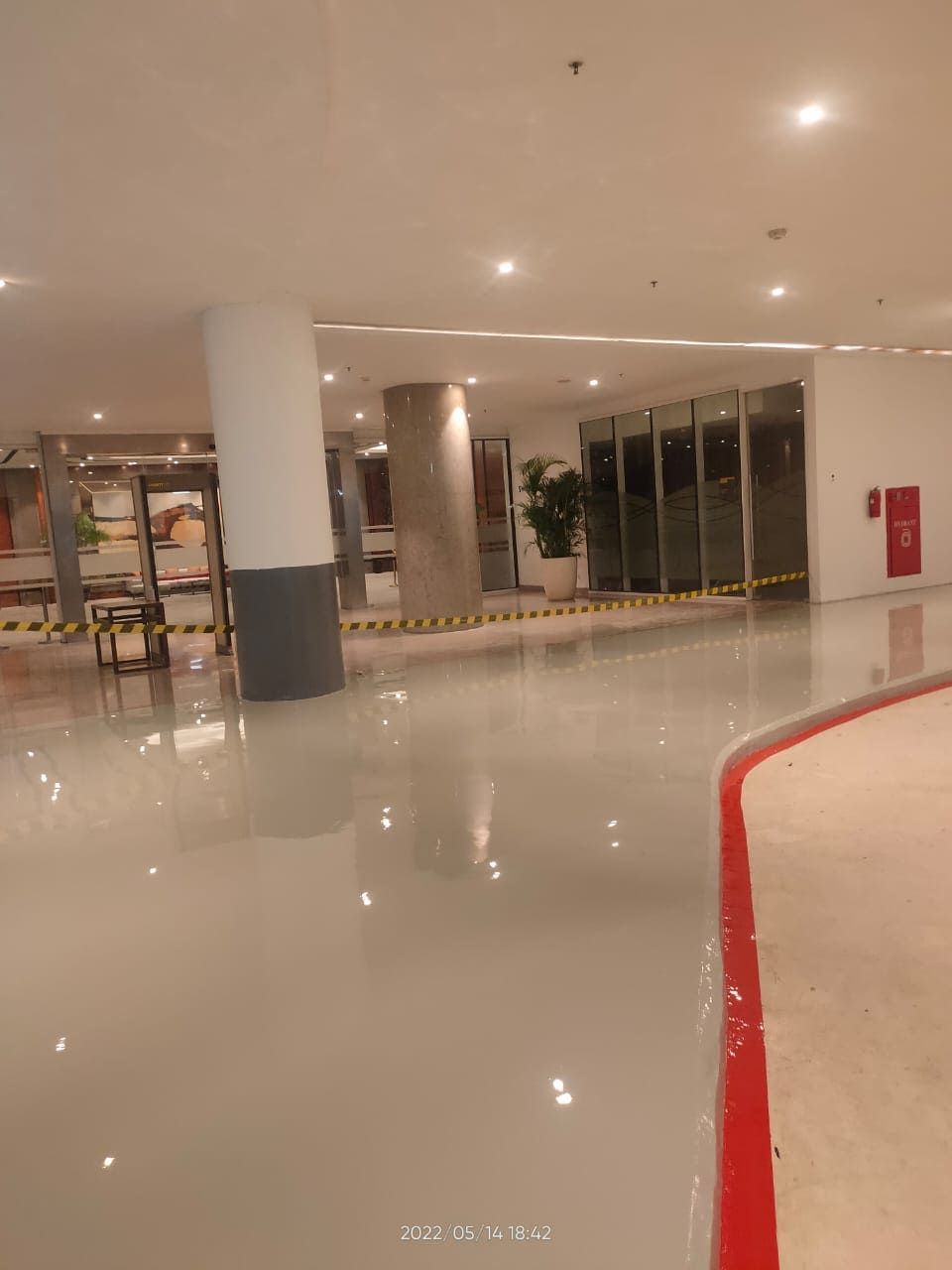 Koridor Swissotel Jakarta PIK Avenue dengan lantai epoxy krem yang memantulkan lampu (6/8)