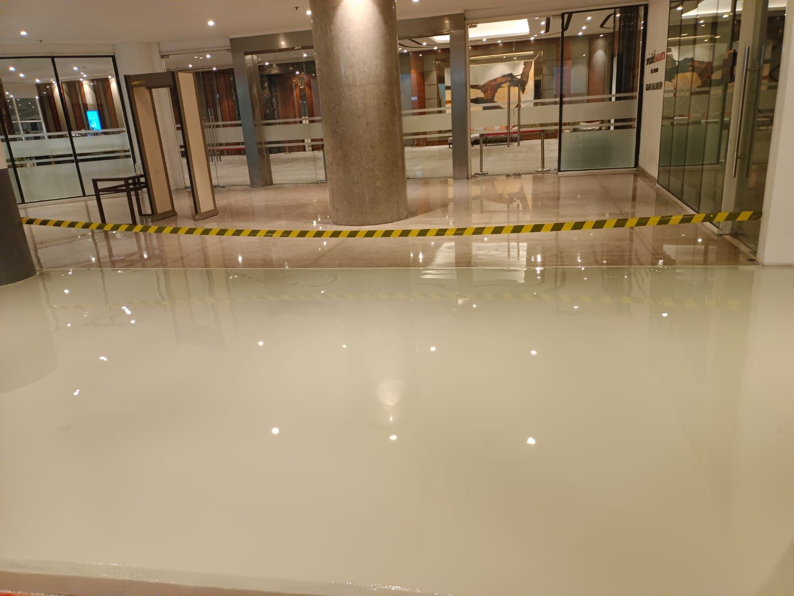 Koridor Swissotel Jakarta PIK Avenue dengan lantai epoxy krem yang memantulkan lampu