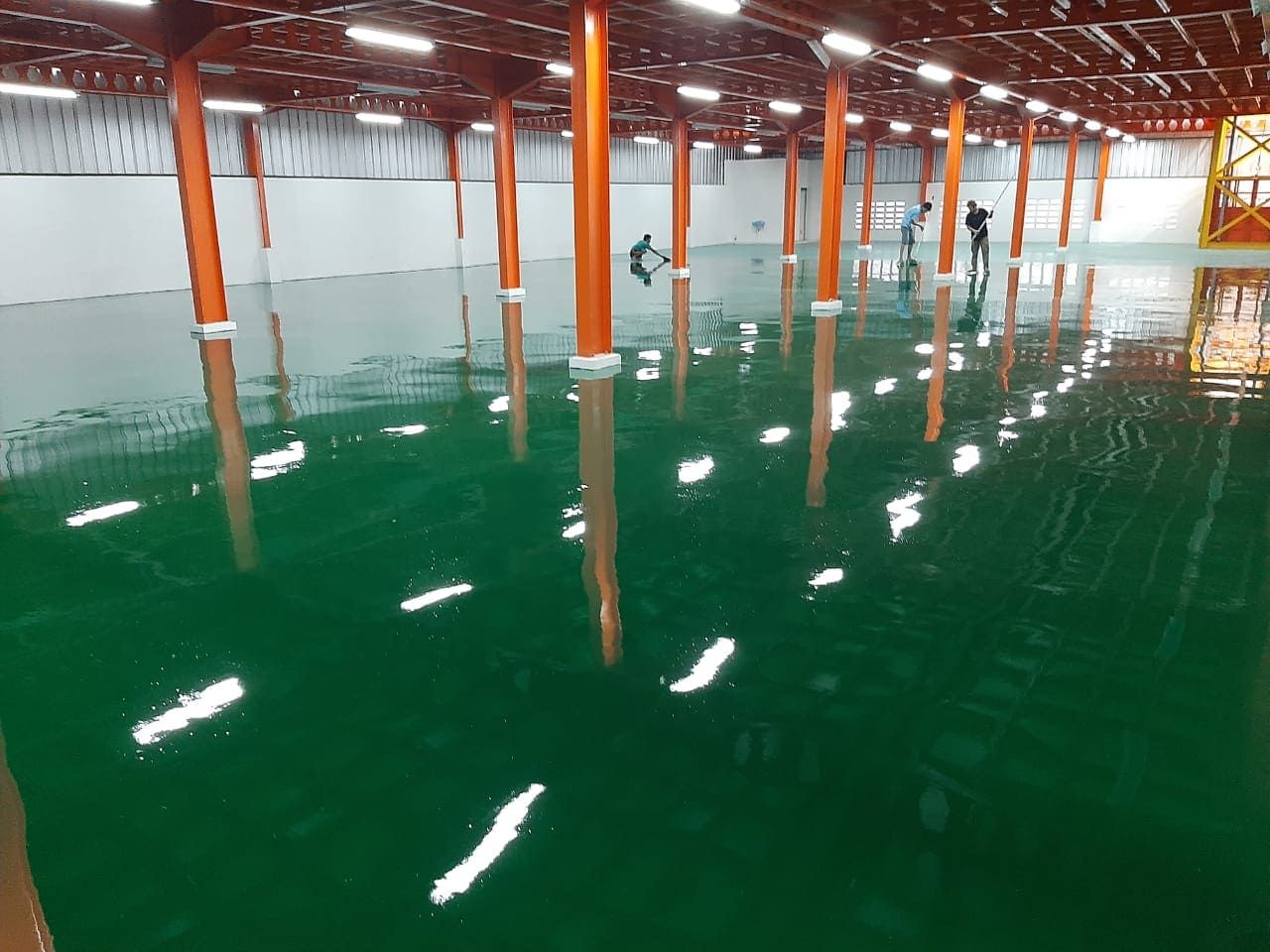 Lantai epoxy hijau di antara kolom oranye pada pabrik Terang Parts Indonesia (2/4)