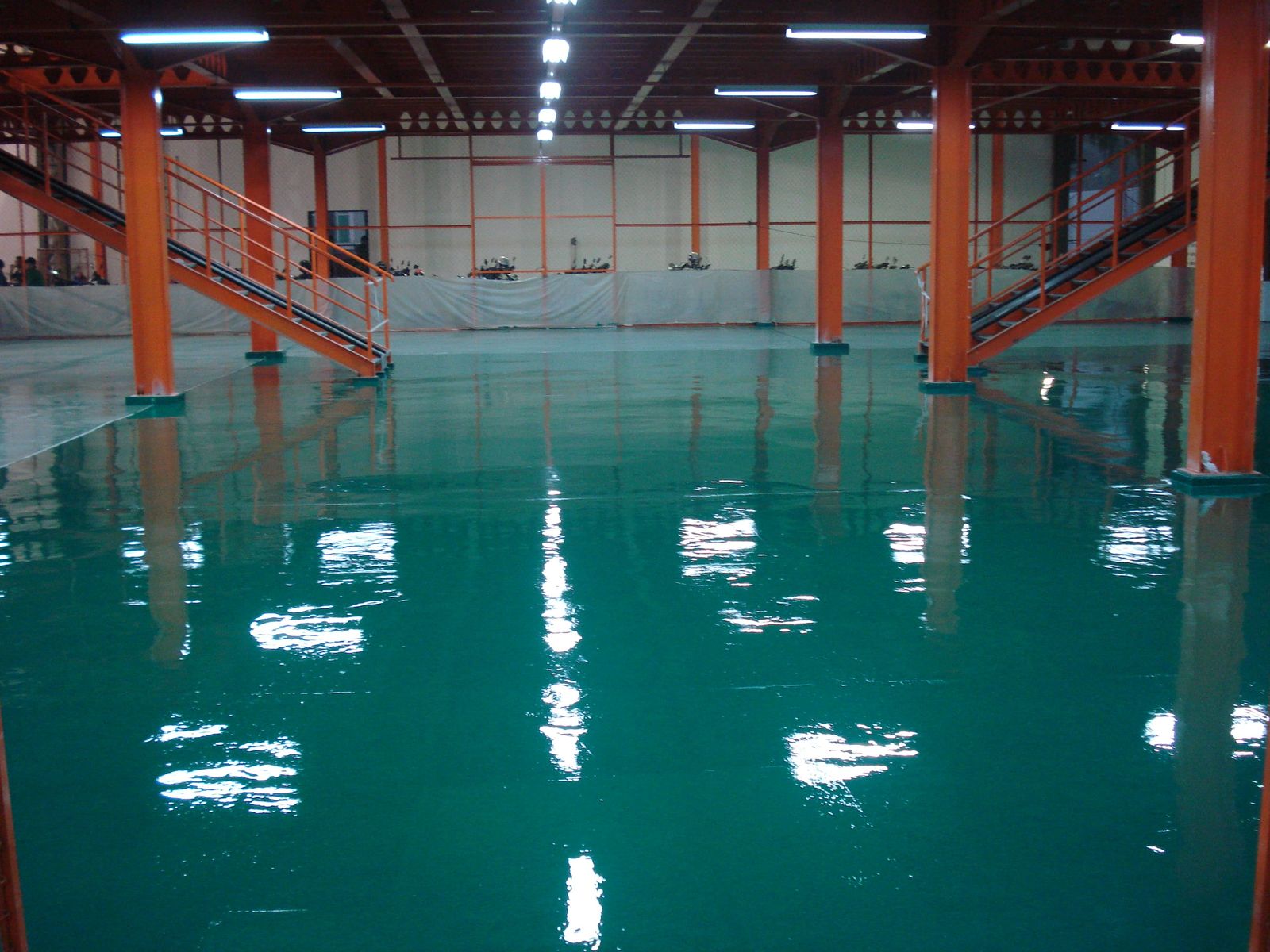 Lantai epoxy hijau di antara kolom oranye pada pabrik Terang Parts Indonesia (3/4)