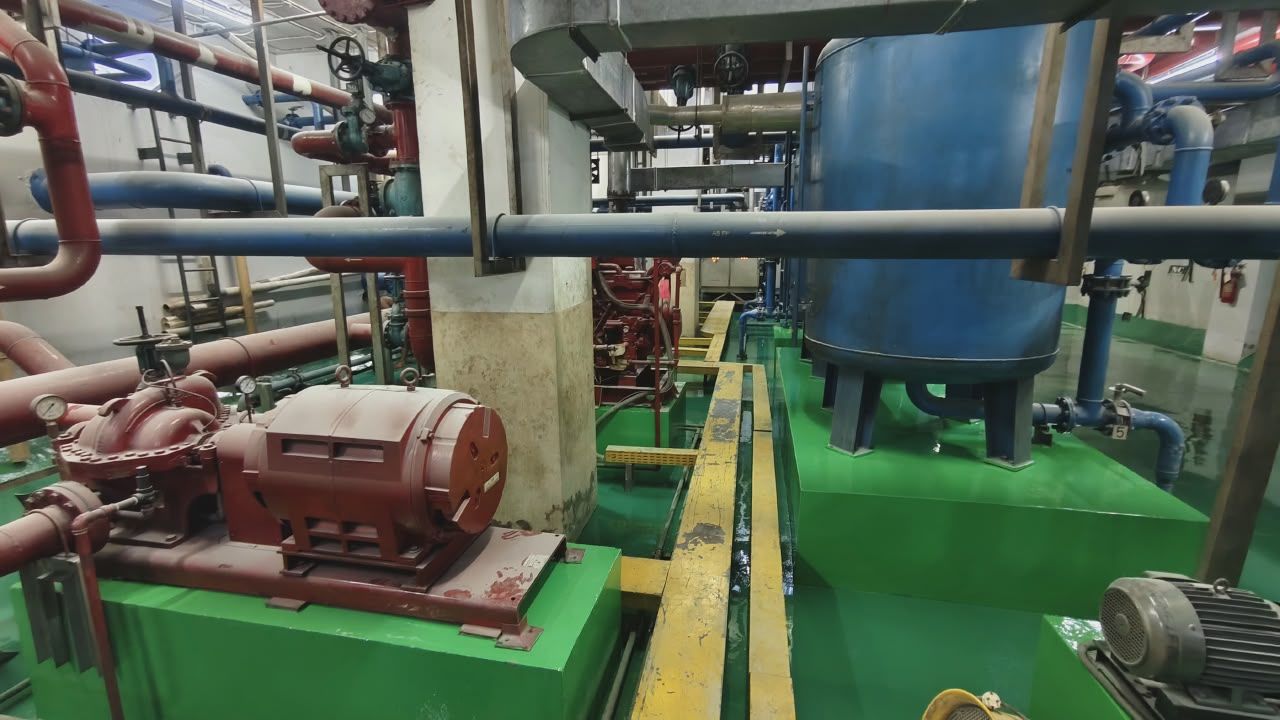 Ruang pompa Thamrin Residences dengan lantai epoxy hijau di bawah jaringan pipa