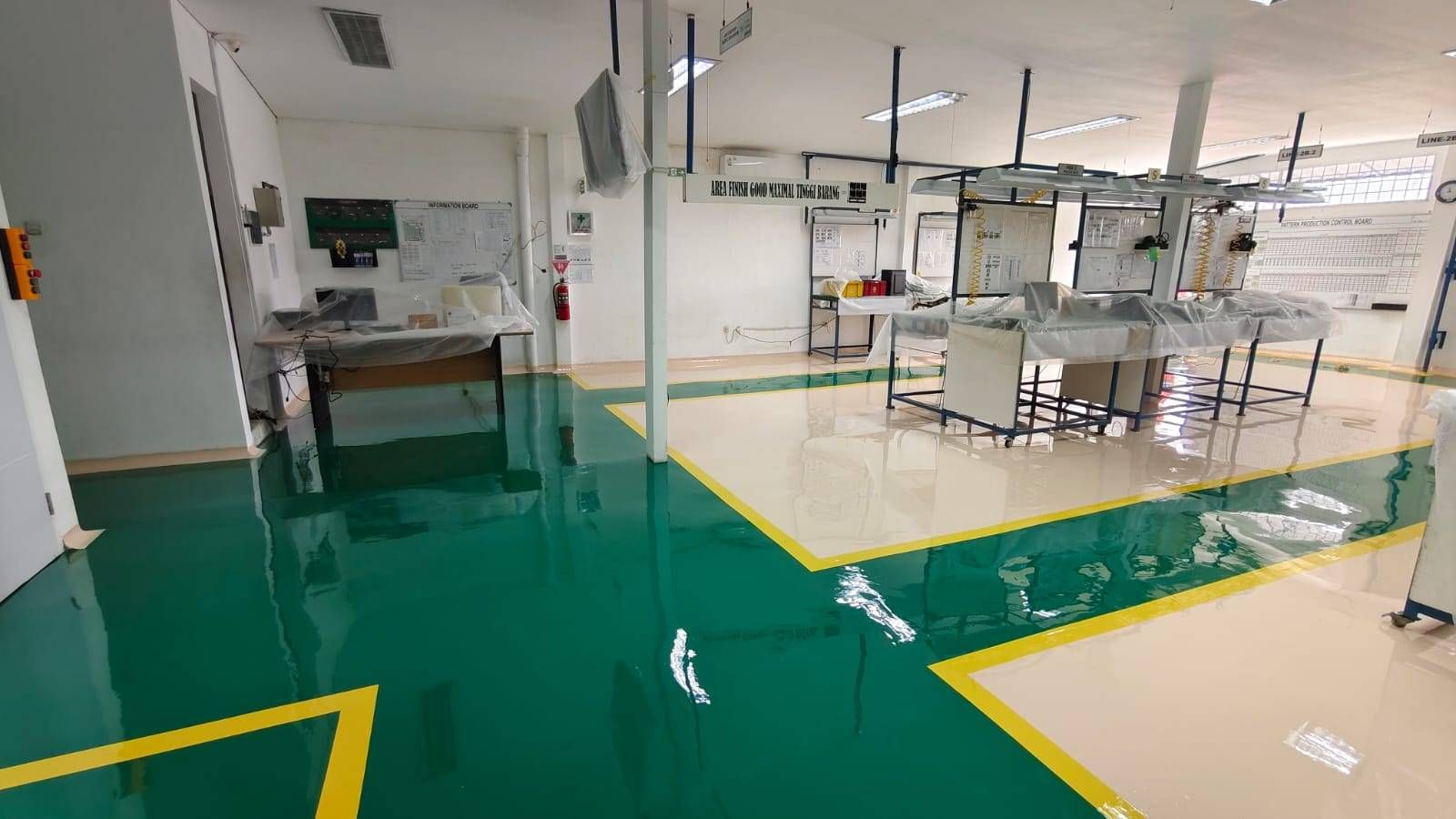 Lantai epoxy putih dengan zona hijau dan marka kuning di ruang perakitan Vega Mandiri (6/9)