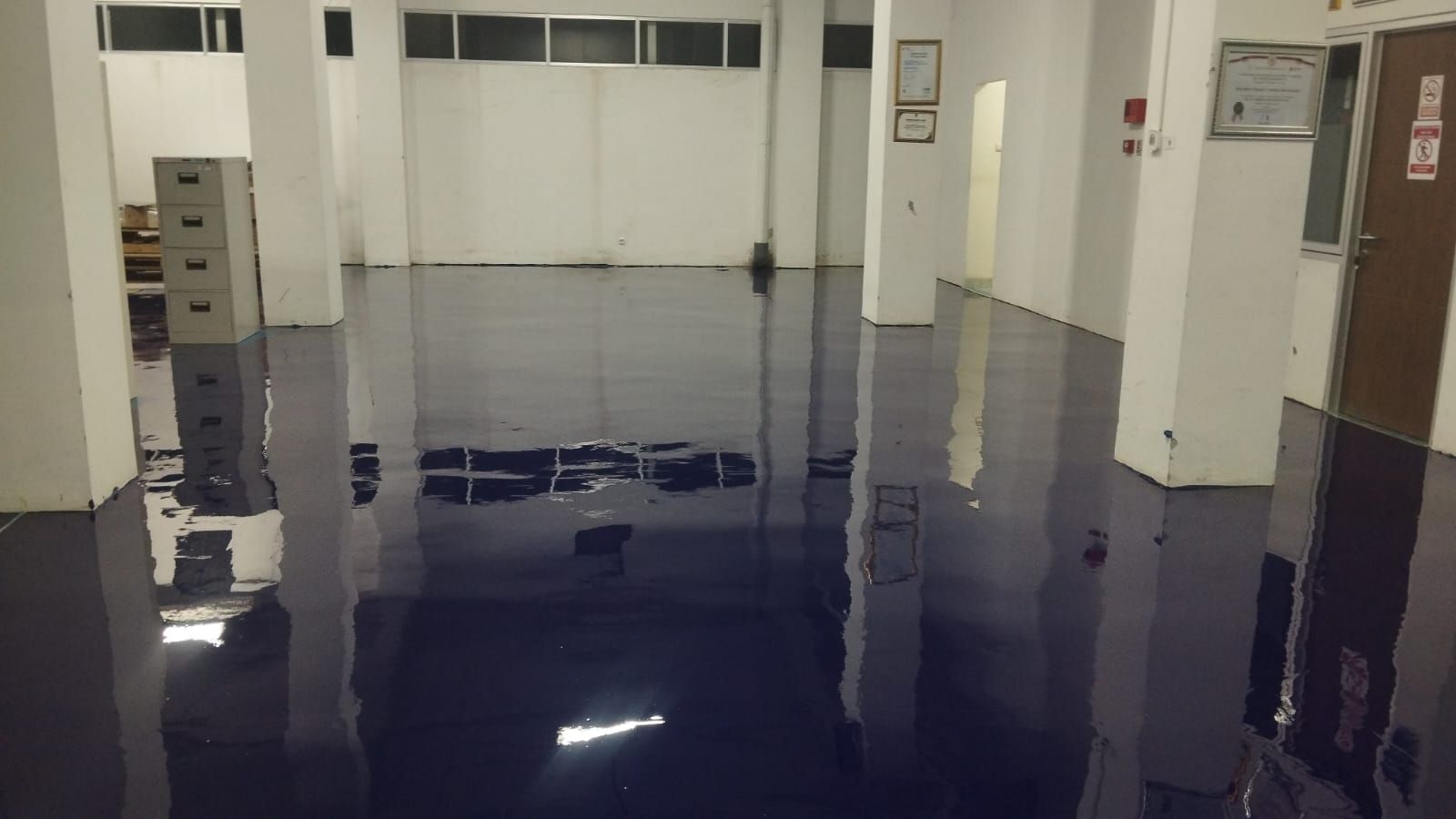 Lantai epoxy biru tua mengilap di ruang produksi Vertikal Agro Teknik Utama